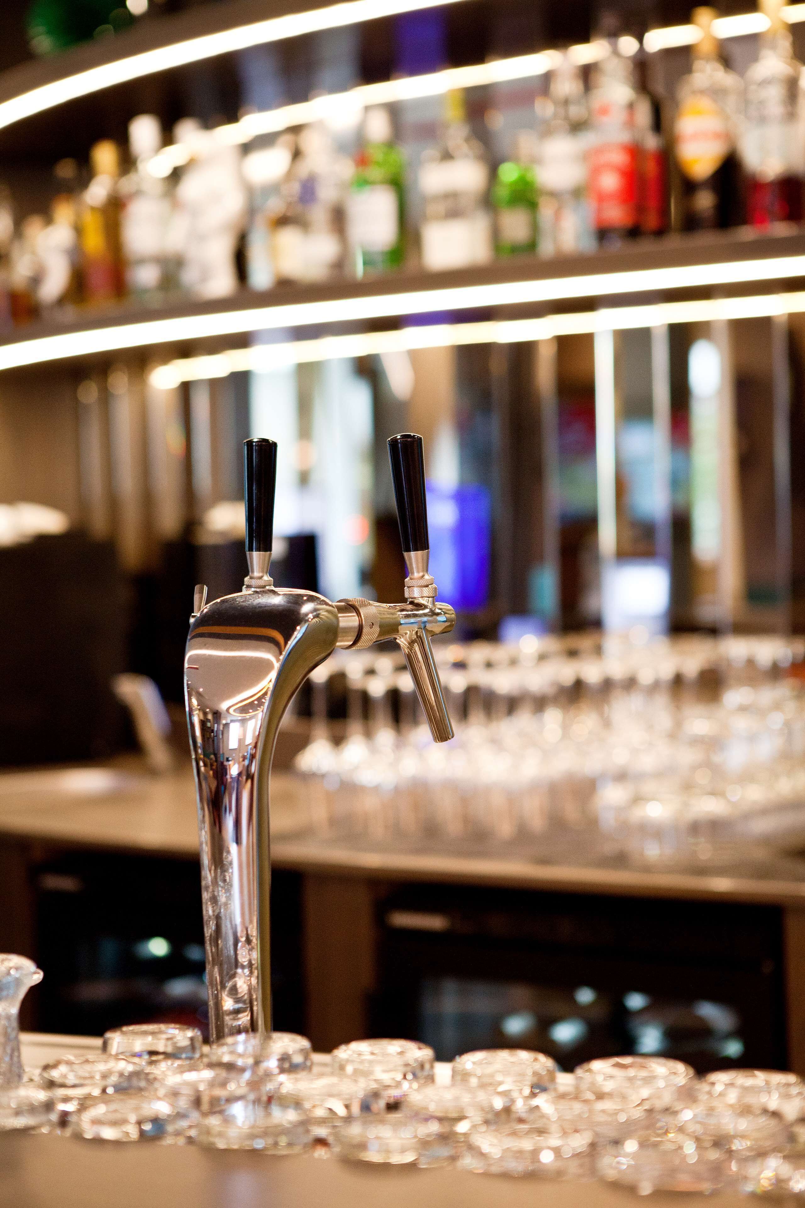 A bar area with a tap and glasses.
