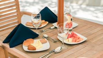 A table set with plates of food, glasses, and a pitcher.
