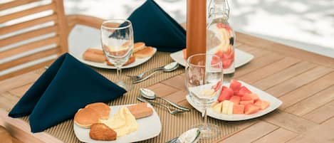 A table set with plates of food, glasses, and a pitcher.