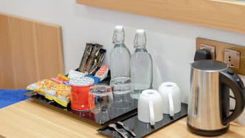 Una bandeja con aperitivos, vasos y una tetera sobre una mesa de madera.