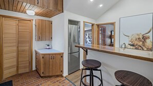 Eine moderne Küche mit Holzausstattung, einem Edelstahlkühlschrank und einer Holz Arbeitsplatte.