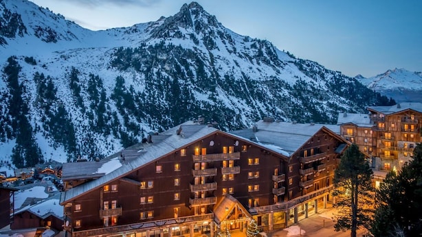 A multi-story lodge with balconies and a ski slope in the background. - 100m from ski slopes, fitness, swimming pool, sauna, balcony, fireplace or stove, tv, ski locker (Les Arcs)
