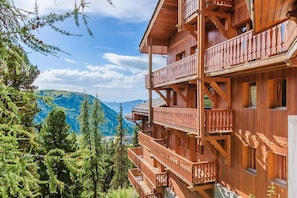 Experience the charm of traditional Alpine architecture in this cozy chalet, featuring balconies with ornate details and a serene natural setting.