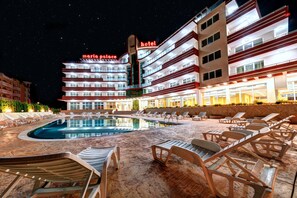 A hotel with a pool area, lounge chairs, and a night-time view of the building. - Maria Palace-Hotel All inclusive (Sunny Beach)