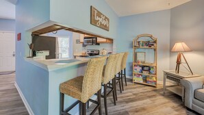 Eine Küche mit Bar, einem Bücherregal und einer Lampe.