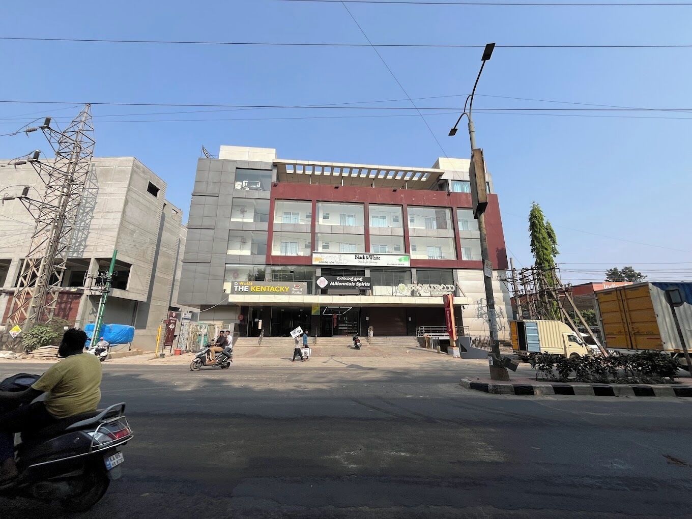 Een meerlaags gebouw met commerciële bedrijven op de begane grond, waaronder een bioscoop en een restaurant.