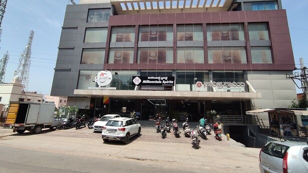 Un edificio de varios pisos con un letrero que dice 'Millennials Spirits' y 'Grill Indian Bar'.