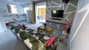 Uma sala de estar moderna com um sofá, uma mesinha e uma televisão.