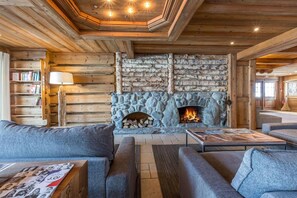 Cozy space with a stone fireplace, two sofas, and a coffee table, perfect for relaxation and socializing.