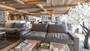 A cozy living area with a sofa, coffee table, and decorative elements like a polar bear sculpture and a tree. - 200m from resort center, 1st floor, view ski slopes, fitness, swimming pool, sauna, hammam, terrace (Saint-Martin-de-Belleville)