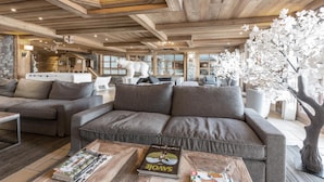 A cozy living area with a sofa, coffee table, and decorative elements like a polar bear sculpture and a tree. - 200m from resort center, 3rd floor, view mountain, fitness, swimming pool, sauna, hammam, balcony (Saint-Martin-de-Belleville)