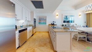 Eine moderne Küche mit weißen Schränken, einem eingebauten Geschirrspüler und einer Arbeitsplatte aus Granit.