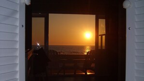 Un espace intérieur offrant une vue sur le coucher de soleil sur l’océan.