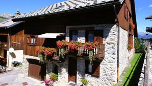 A traditional stone building with wooden balconies and flower boxes. - Crève Tête 3 rooms 60 m2 200 m from the free bus stop and 300 m from the ski lift (LES AVANCHERS VALMOREL)