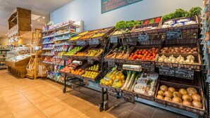 A grocery store with various fruits and vegetables on display, including baskets of apples, oranges, and tomatoes. - 150m from ski slopes, fitness, swimming pool, sauna, fireplace or stove, tv, ski locker, 160m² (Les Arcs)