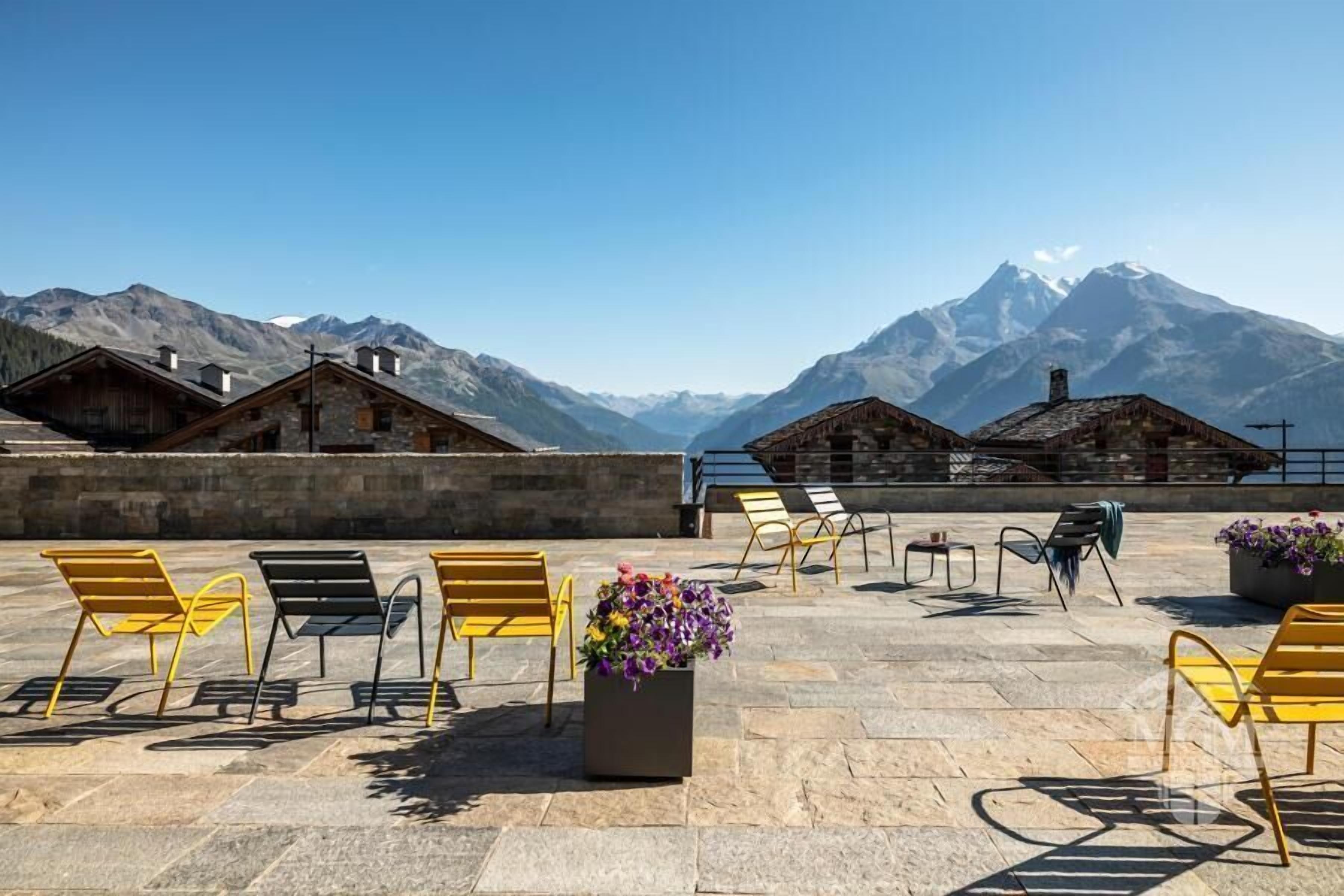 Eine Terrasse mit Sitzgelegenheiten und Blick auf die Berge.