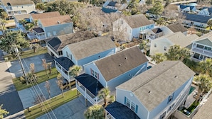 A residential area with houses, a swimming pool, and a view of the ocean. - 4BR Cottage with Private Pool & Walk to Beach (Surfside Beach)