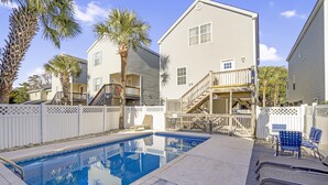 A swimming pool with a wooden deck, lounge chairs, and a white fence. - 4BR Cottage with Private Pool & Walk to Beach (Surfside Beach)