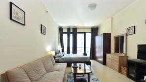 Una habitación de hotel con cama, sofá, televisión y escritorio.