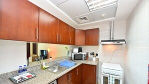 Una cocina funcional con gabinetes de madera, microondas, estufa y lavaplatos.