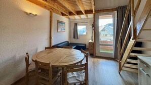 A room with a wooden dining table, a bench, and a staircase. - 300m from ski lifts, 3rd floor, balcony, tv, ski locker, 31m², Alpe d'Huez (L'Alpe d'Huez)