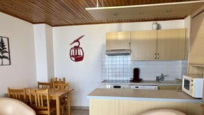 A compact living space with a dining area, a kitchenette, and a seating area with two sofas. - 30m from ski slopes, 1st floor, balcony, tv, ski locker, 32m², Alpe d'Huez (L'Alpe d'Huez)