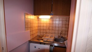 A compact kitchen with a refrigerator, a sink, and a countertop. - 5th floor, tv, 16m², Alpe d'Huez (L'Alpe d'Huez)