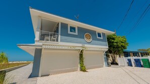 Une maison à deux étages avec un garage, un balcon et une antenne parabolique.