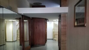 A corridor with a mirrored wall, a wooden panel, and a staircase. - Department Moreno Center 2366 (Mar del Plata)