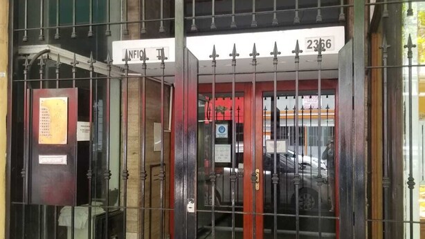 A gated entrance with a metal fence, a sign with the number 2366, and a red door. - Department Moreno Center 2366 (Mar del Plata)