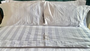 A bed with white pillows and a striped bedspread. - Loft Milan Valkyrie (Valqurico)