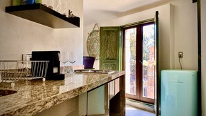 A kitchen with a marble countertop, a coffee machine, wine glasses, and a vintage refrigerator. - Loft Milan Valkyrie (Valqurico)