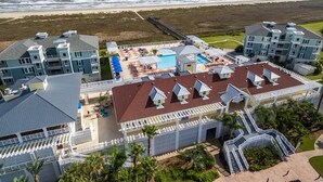 A beachfront hotel with multiple buildings, a swimming pool, and a boardwalk leading to the beach. - Saltwater Breeze- Book 5+ nights & get 15% off -Beach Front-3BD/2BA. Sleeps 9 (Galveston)