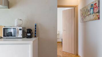 Business Apartment | Private kitchen | Mini-fridge, electric kettle, cookware/dishes/utensils, dining tables