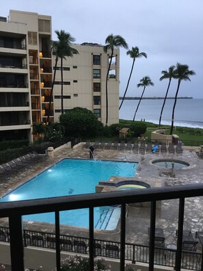 A swimming pool with lounge chairs and a view of the ocean.