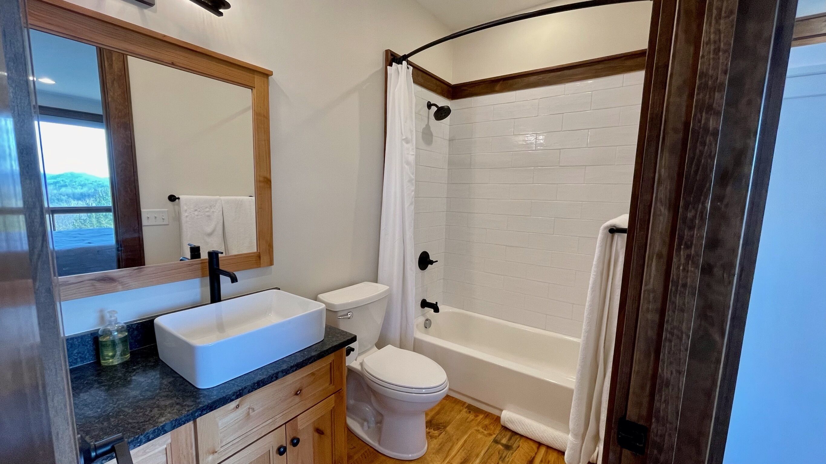 Un baño con lavamanos, inodoro y bañera blancos.