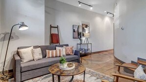 A modern living room with a grey sofa, a round coffee table, and a floor lamp.