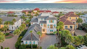 Un quartier résidentiel en bord de mer offrant une vue sur la plage, avec des maisons aux toits rouges et une plage en arrière-plan.