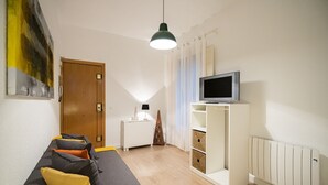 Una sala de estar moderna con sofá, televisor y mueble de almacenaje.