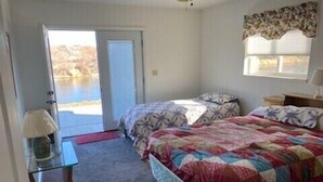 A bedroom with a bed, a desk, and a window.
