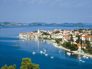 A coastal town with a marina filled with boats, surrounded by white buildings with red roofs, and a clear blue sky. - Pirovac - Dalmatia's Most Beautiful Beaches (Pirovac)