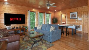 A cozy living room with a flat-screen TV, a sofa, a coffee table, and a pool table. - Bella Yani - Hot Tub, Pool Table, & Air Hockey! (Sevierville)