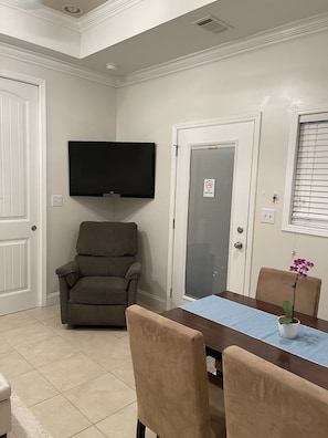 Relax in this stylish living room with a flat-screen TV, comfortable seating, and a dining area.