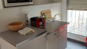 Een keuken met een magnetron, een houten kom en een rode apparatuur op het aanrecht.