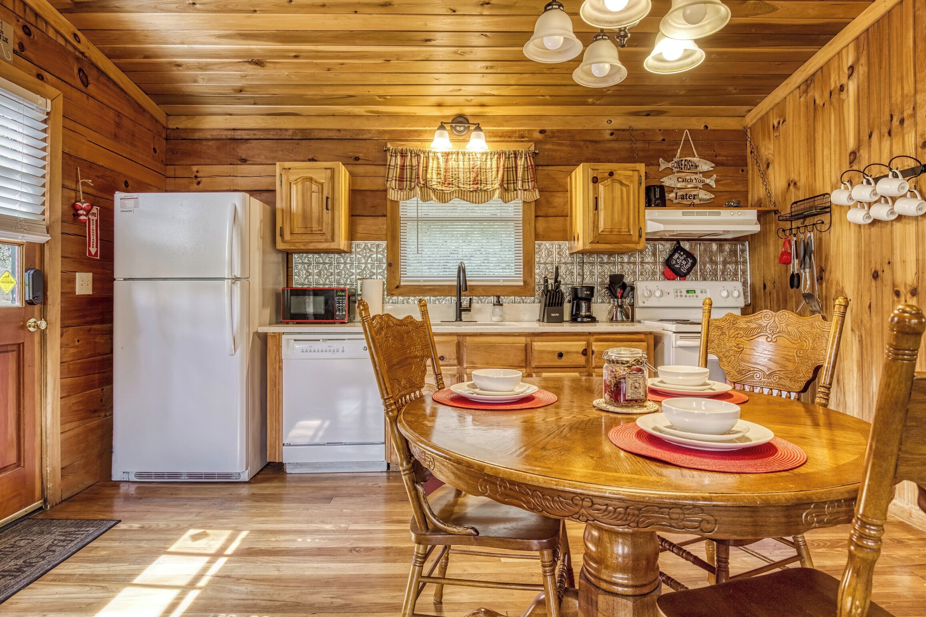 L’intérieur d’un chalet en bois comprend une cuisine, une table à manger et des chaises.