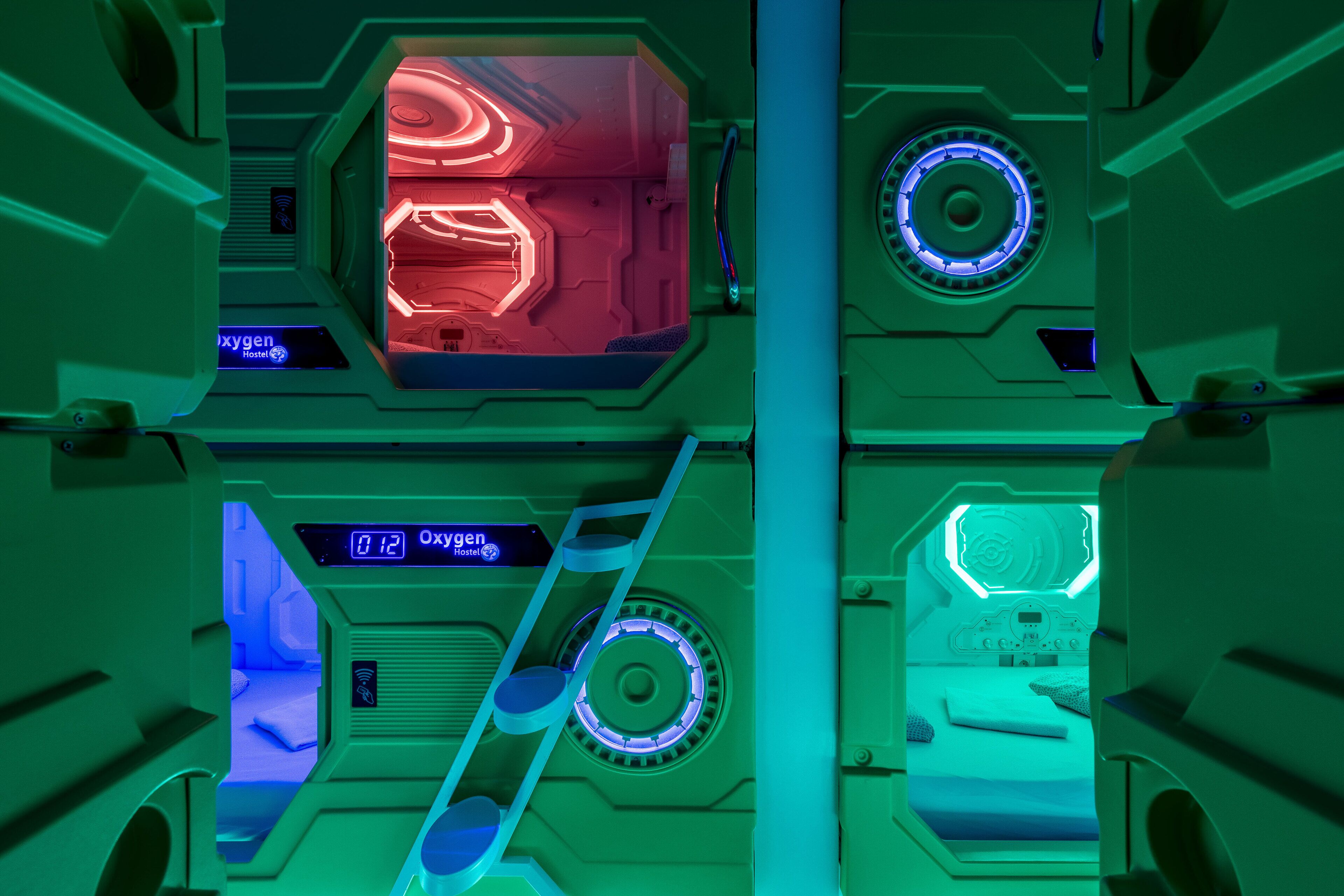 Un interior futurista con paneles hexagonales, una pantalla digital y una escalera que lleva a una plataforma.