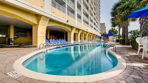 A swimming pool with lounge chairs and a building with balconies in the background. - 15th floor 3 bedroom/2 bath condo with million dollar views! (Myrtle Beach)