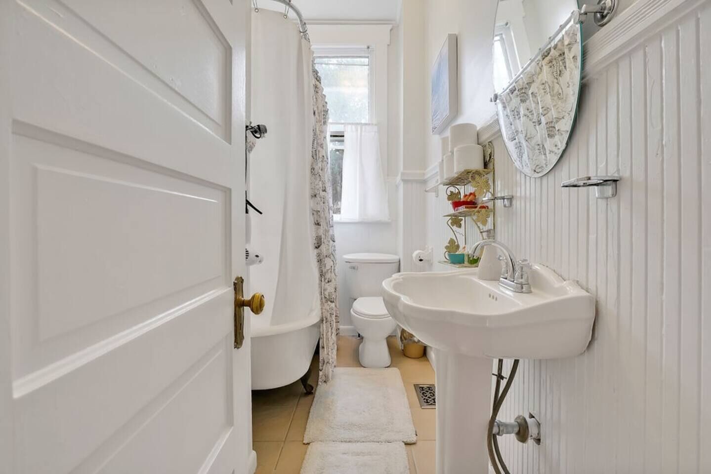 Une salle de bain avec un lavabo, des toilettes et une baignoire, le tout de couleur blanche.