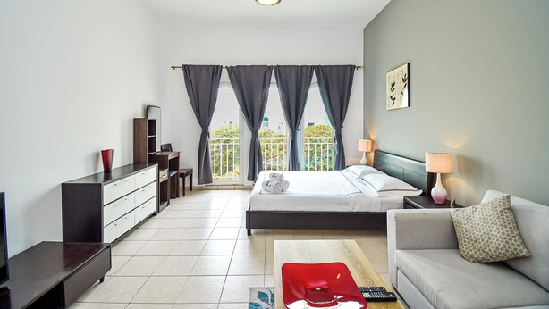 Une chambre d’hôtel moderne équipée d’un lit, d’un canapé, d’un bureau et d’une télévision.