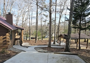 Escape to a serene wooded retreat with a cabin-style lodging surrounded by trees and outdoor recreational facilities.